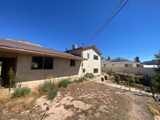 Stucco exterior with multiple windows and a shingle roof