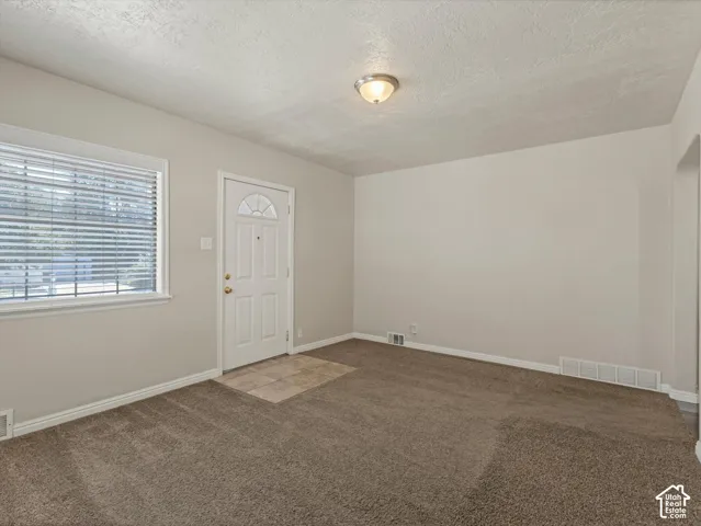 Carpeted flooring, neutral wall tones, white trim, and a semi-flush mount ceiling fixture