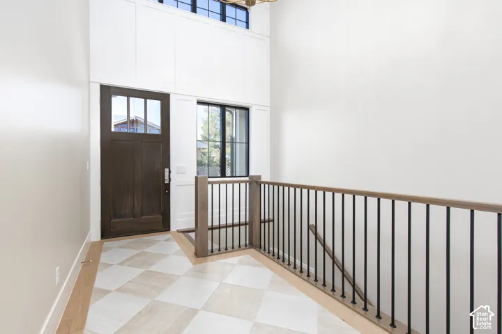 Foyer with soaring ceilings and abundant natural light from transom windows above