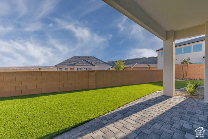 Expansive backyard oasis featuring a lush, manicured lawn bordered by a substantial brick privacy fence