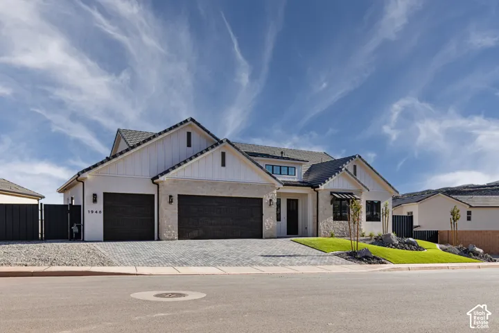 Modern two-story residence featuring a striking stone and stucco exterior with peaked rooflines and architectural detailing