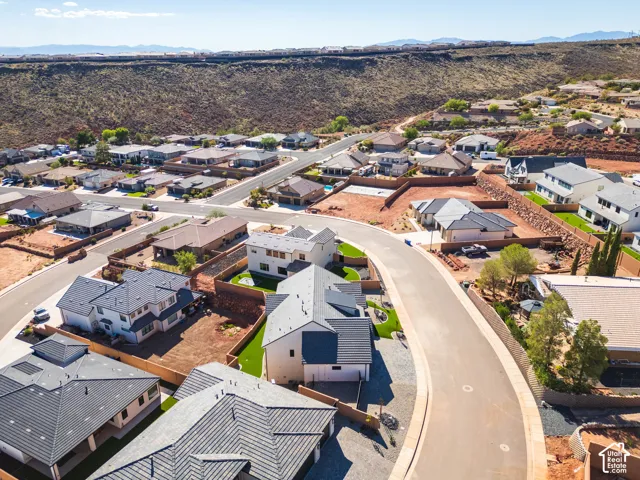 Residential community with established homes and undeveloped lots, surrounded by natural desert terrain