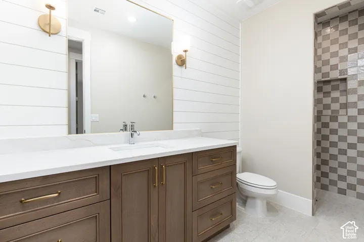 Vanity with a white countertop and integrated sink, chrome faucet, and brass hardware