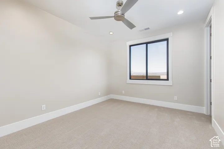 Recessed lighting, ceiling fan, carpeted flooring, and a large window with black trim