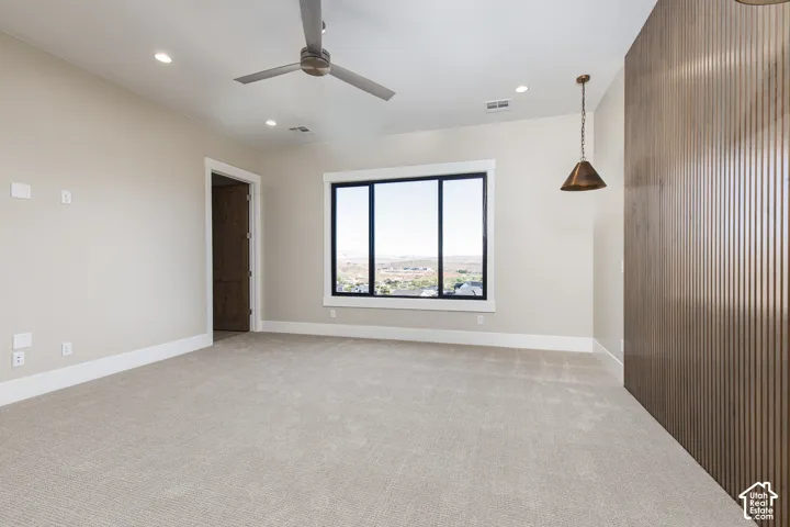 Neutral-toned carpeting, recessed lighting, and a modern ceiling fan