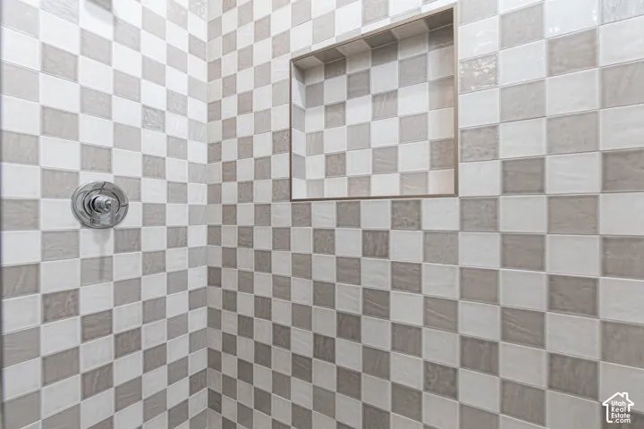 Shower stall with checkerboard tile pattern, recessed niche, and chrome fixtures