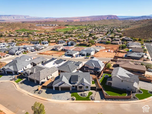 Residential neighborhood with varied architectural styles, mature landscaping, and red rock mountain backdrop