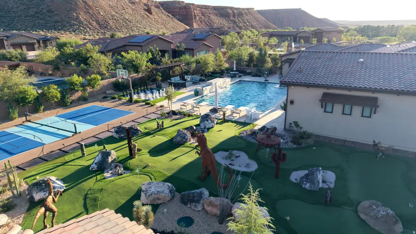 Outdoor swimming pool, multi-court sports area, putting green, and desert landscaping