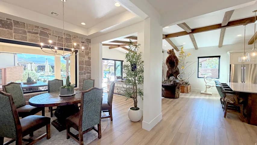 Open-concept living area with wood-finish flooring, exposed beam ceiling accents, and a stone accent wall