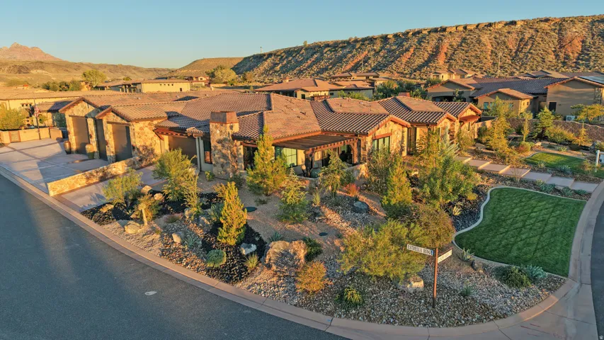 Stone-clad exterior, tile roof, mature landscaping, integrated pergola, and a curved paved driveway