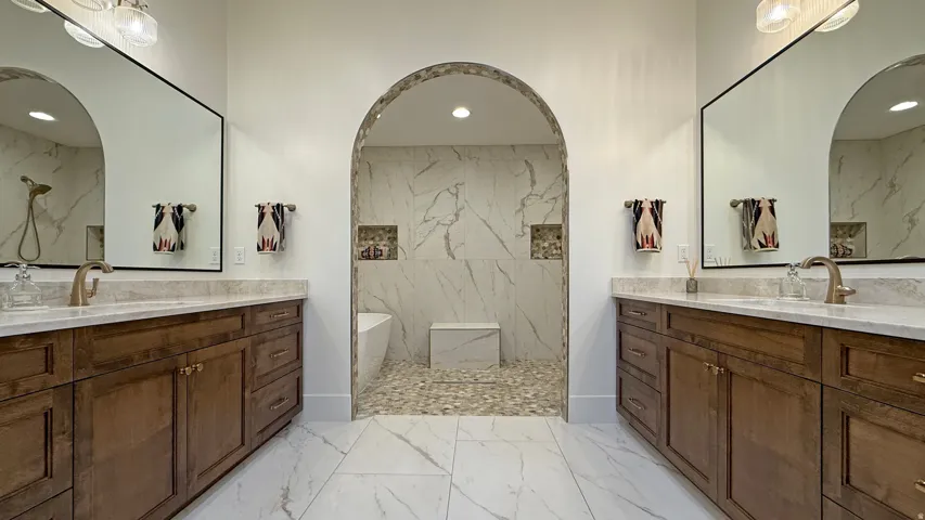 Dual wood-finish vanities with light-toned countertops and undermount sinks