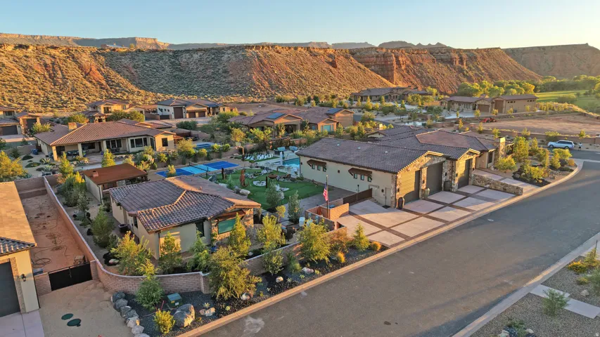 Stucco exterior with stone accents, tiled roofing, and a paver driveway