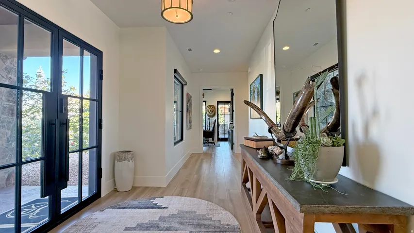 Entryway featuring a large black-framed glass door, wood-finish flooring, recessed lighting, and a contemporary ceiling fixture
