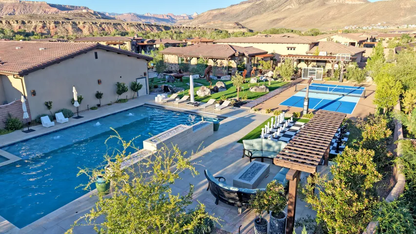 Expansive outdoor living area featuring a swimming pool, integrated spa, sports court, pergola, and large format outdoor chess set