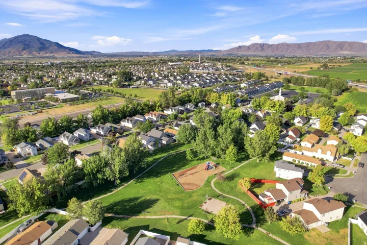 Expansive suburban neighborhood with mountain backdrops and a community park featuring a playground