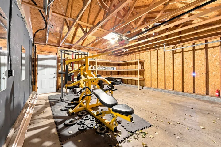 Exposed wood beam ceiling with a skylight and concrete flooring