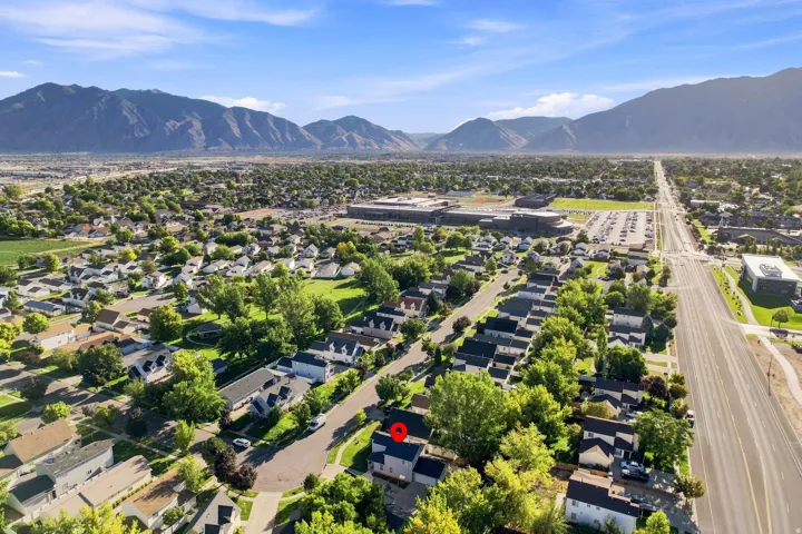 Mountain backdrop, residential neighborhood setting, broad street access, varied tree canopy, and established community surroundings