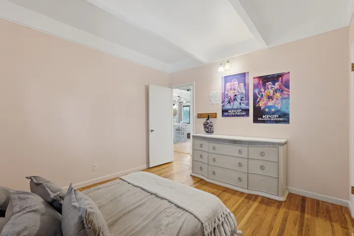 Bedroom #3.  Hardwood flooring, painted walls, and a white ceiling with exposed beams