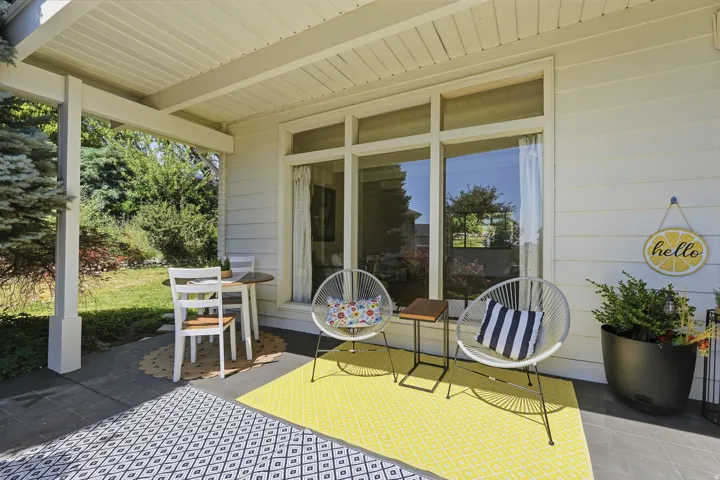 Covered patio with a painted concrete surface, wood-paneled ceiling, and large window
