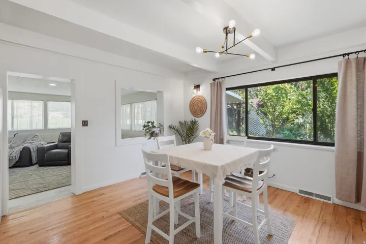 Wood-finish flooring with white walls and exposed ceiling beams