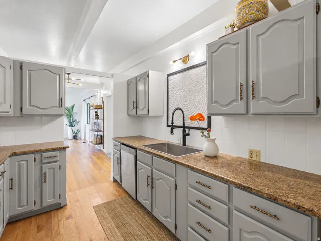 Wood-finish flooring with light gray cabinetry and bronze hardware