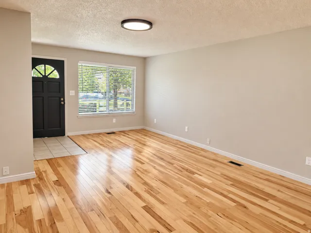 Light wood-finish flooring, neutral wall tones, and a contemporary ceiling light fixture