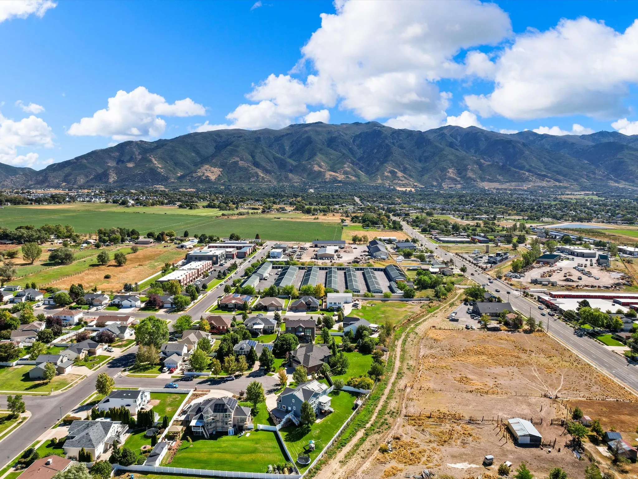Expansive mountain backdrop with scattered residential properties, commercial structures, and undeveloped land