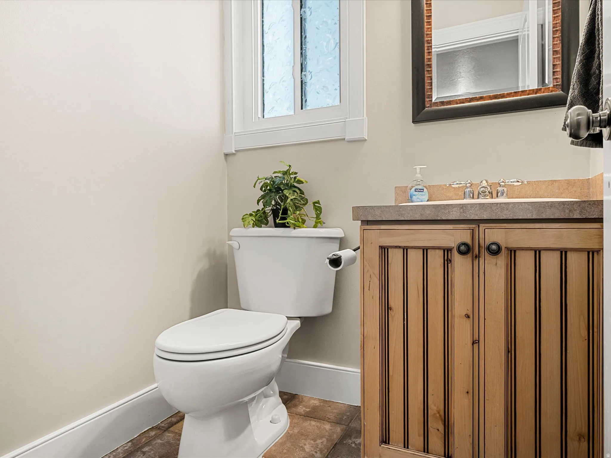 Wood-finish vanity with a stone countertop and an undermount sink