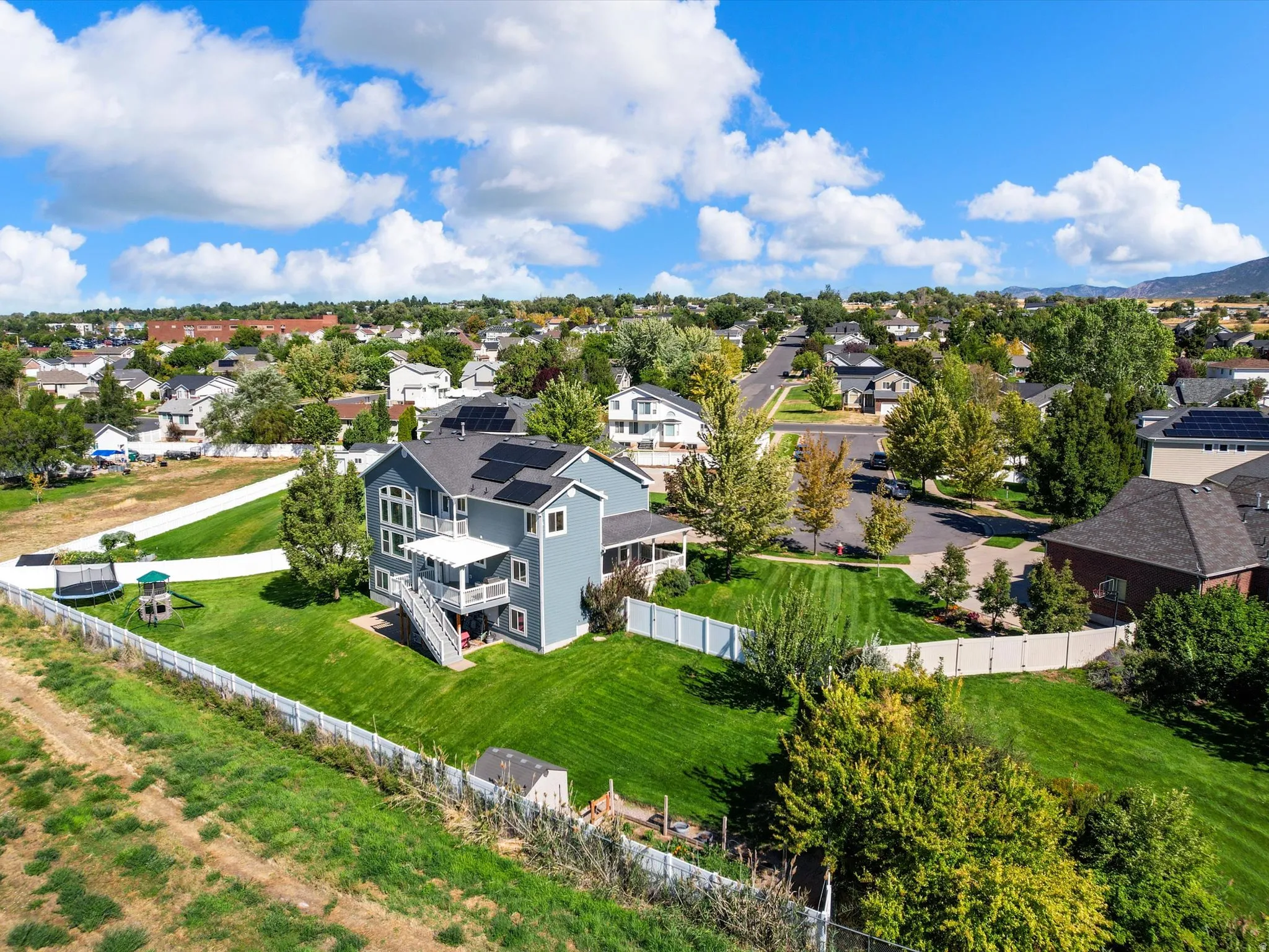 Expansive property with a large, manicured lawn and a multi-level deck