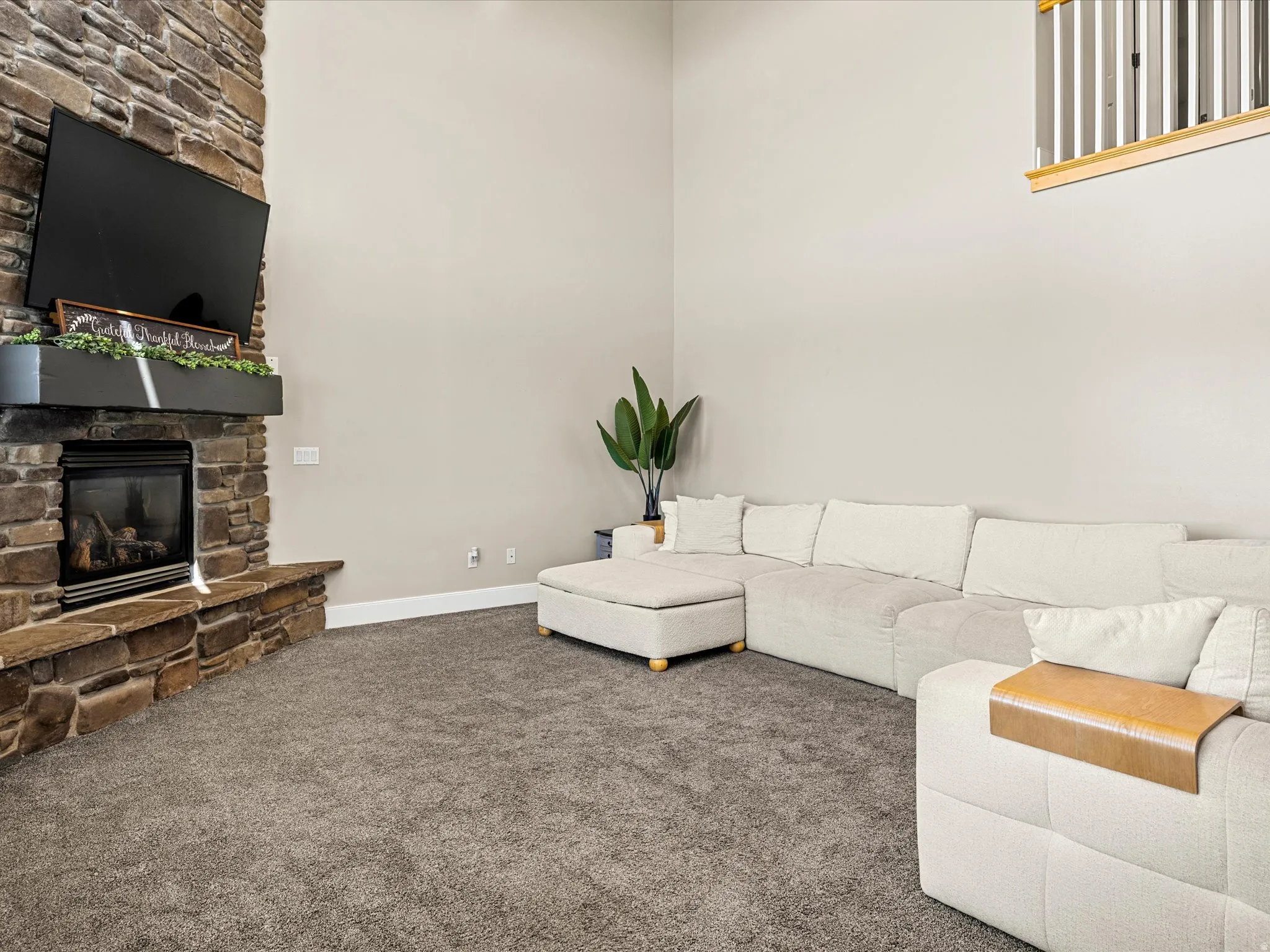 Stone-clad fireplace with a dark wood-finish mantel and integrated gas insert