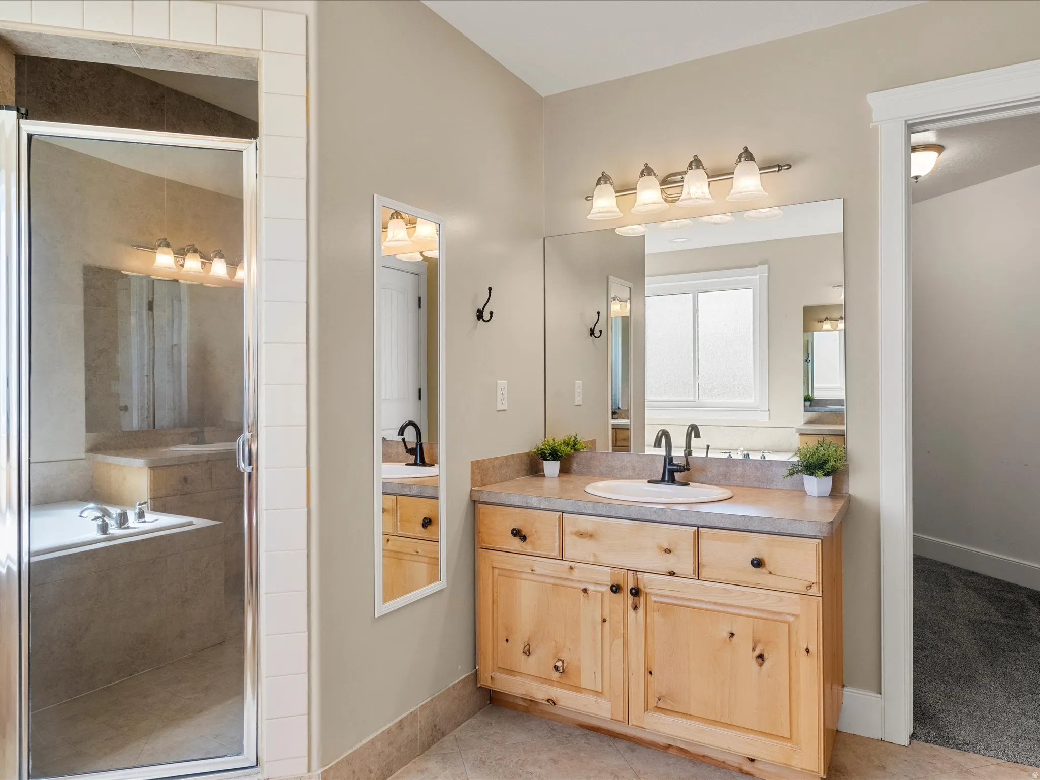 Light wood-finish vanity with a single basin sink and dark-finish faucet