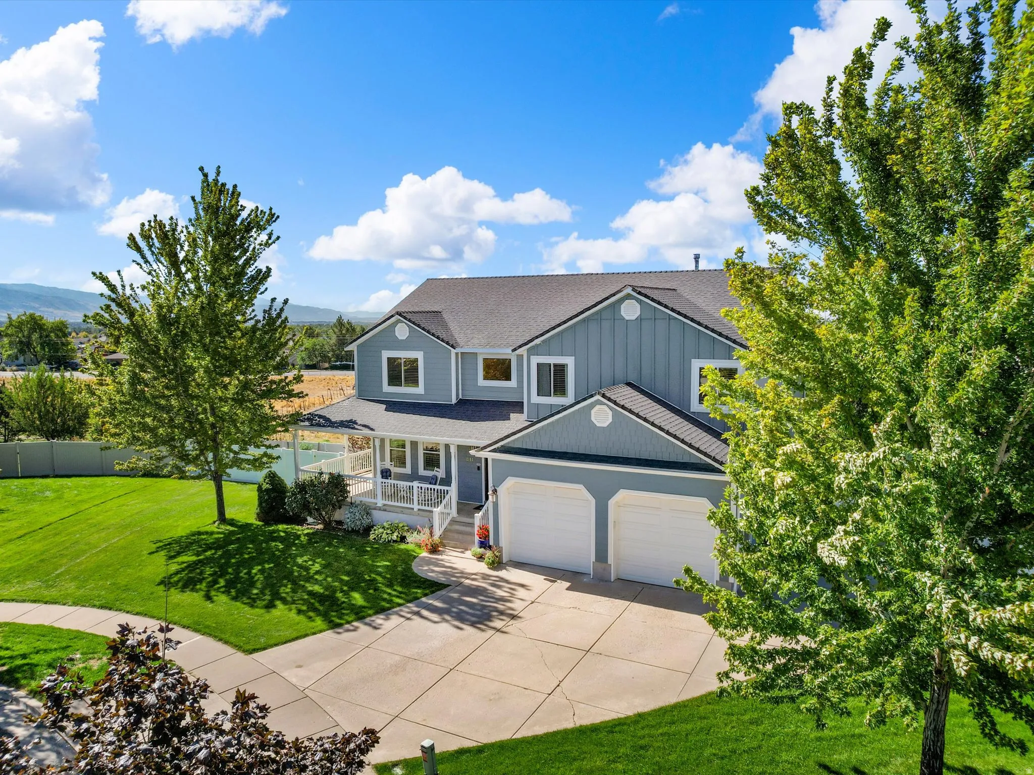 Two-story residence with a covered porch, attached two-car garage, and a concrete driveway