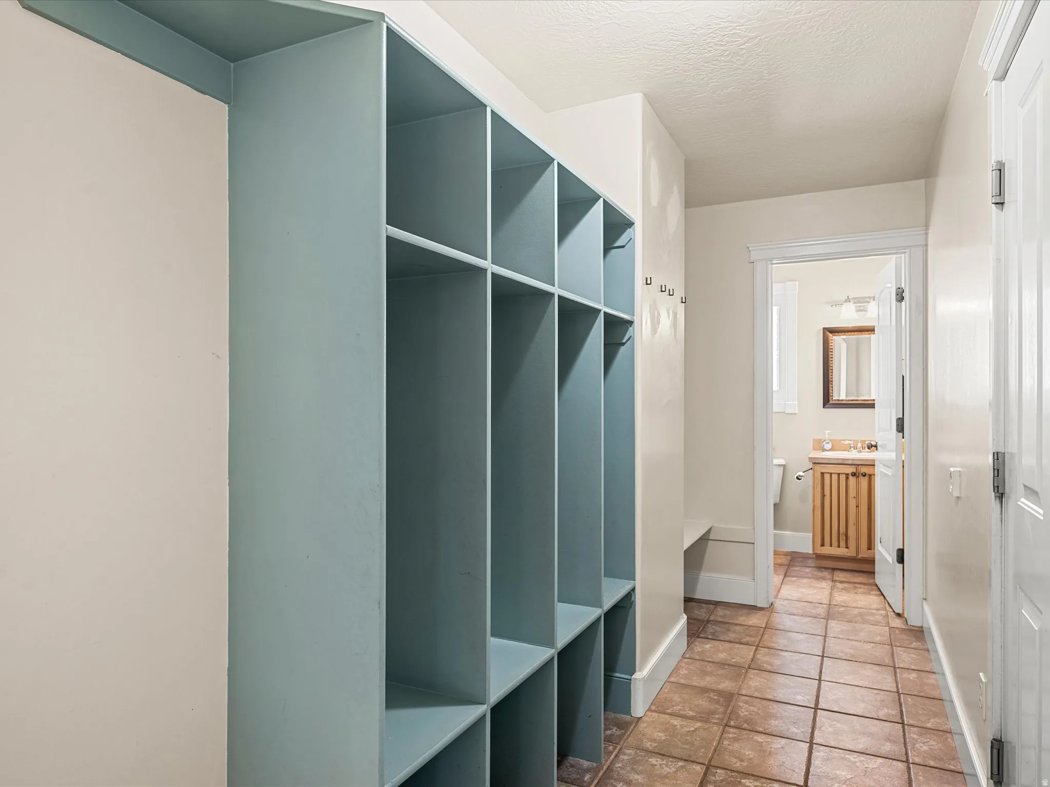 Built-in storage cubbies, wall-mounted coat hooks, and a built-in bench