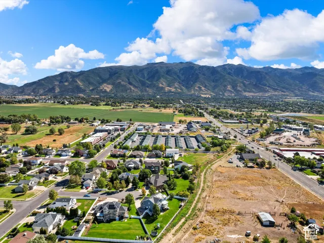 Expansive mountain backdrop with scattered residential properties, commercial structures, and undeveloped land