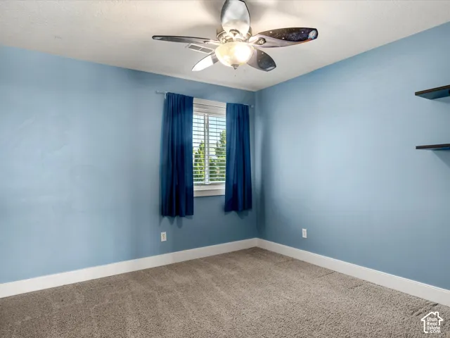 Recessed window with white blinds, wall-mounted shelving, and a ceiling fan with integrated lighting