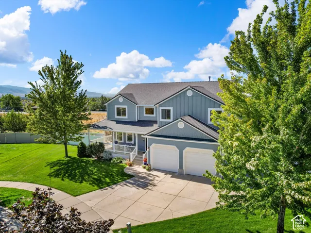 Two-story residence with a covered porch, attached two-car garage, and a concrete driveway