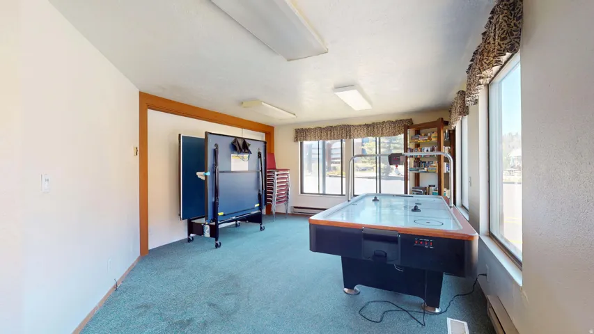 Spacious room with carpet flooring, abundant natural light from multiple windows, and recessed lighting fixtures