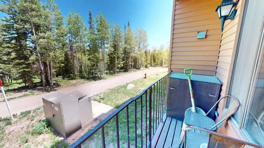Balcony with wood siding and a black metal railing
