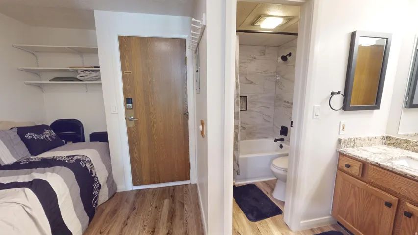 Wood-finish flooring throughout, with a wood-panel entry door