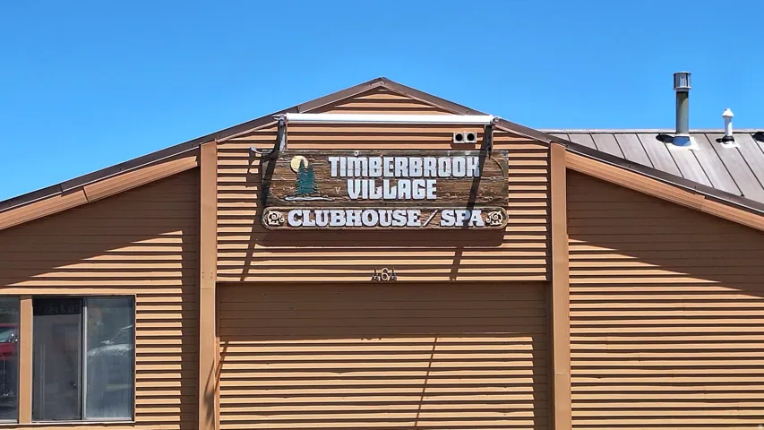 Building with horizontal siding and a prominent signage for Timberbrook Village Clubhouse/Spa