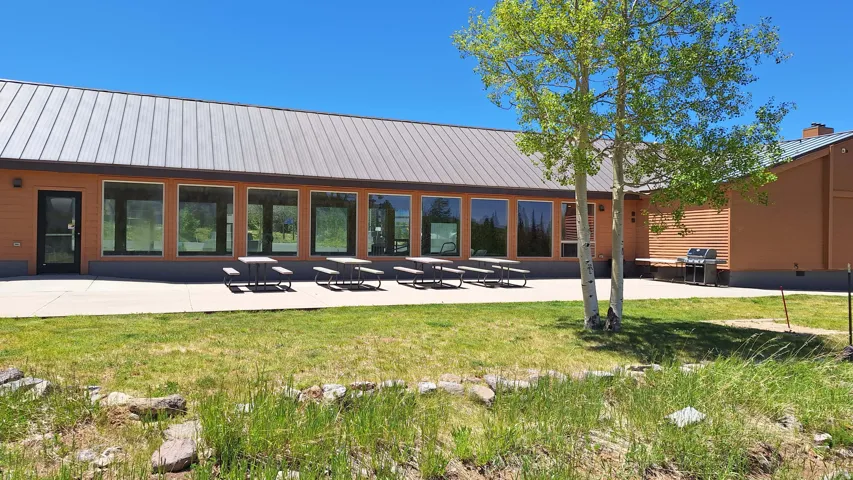 Expansive patio area with multiple large windows, a metal roof, and durable siding