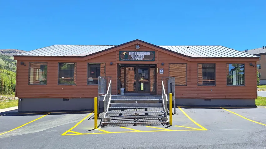 Commercial building with wood-finish siding, a metal roof, and a prominent entrance with steps