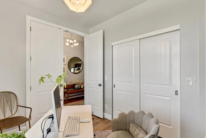 Double doors with panel detailing, white sliding closet doors, wood-finish flooring, and recessed ceiling lighting