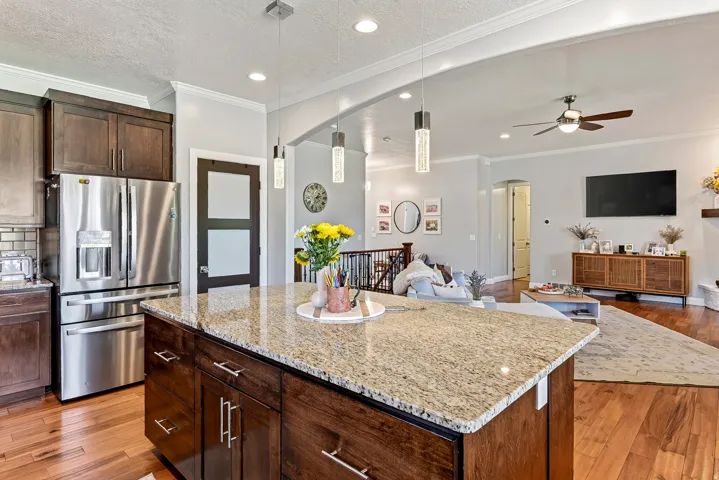 Kitchen island featuring a granite countertop and dark wood cabinetry