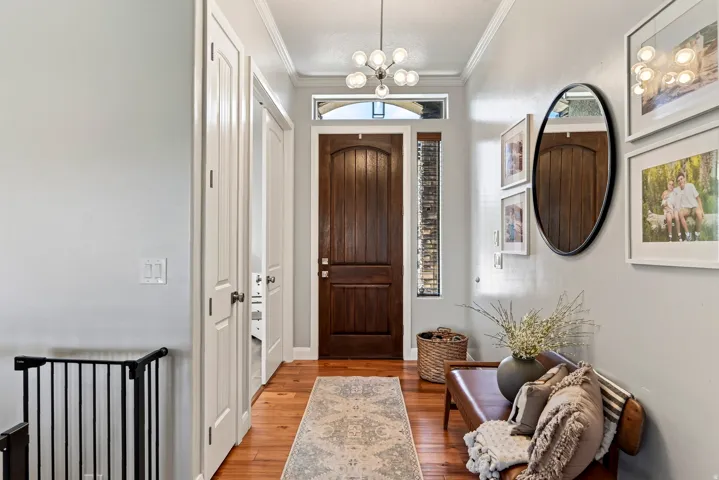 Rich wood-finish entry door with a side light and transom window