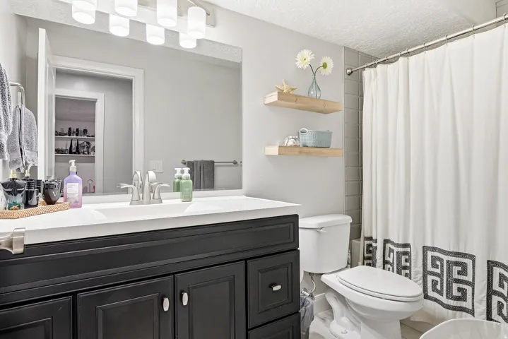 Vanity with black cabinetry, white countertop, and brushed nickel fixtures