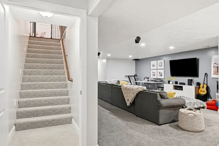 Carpeted staircase with wood handrail