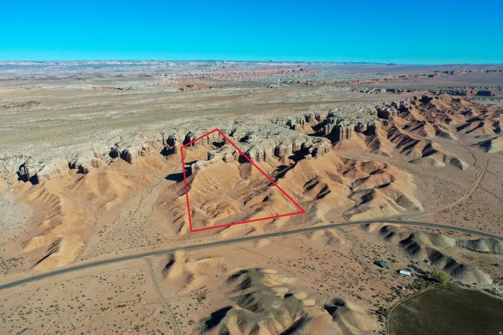 Expansive desert terrain featuring distinct geological formations and a clear, flat horizon