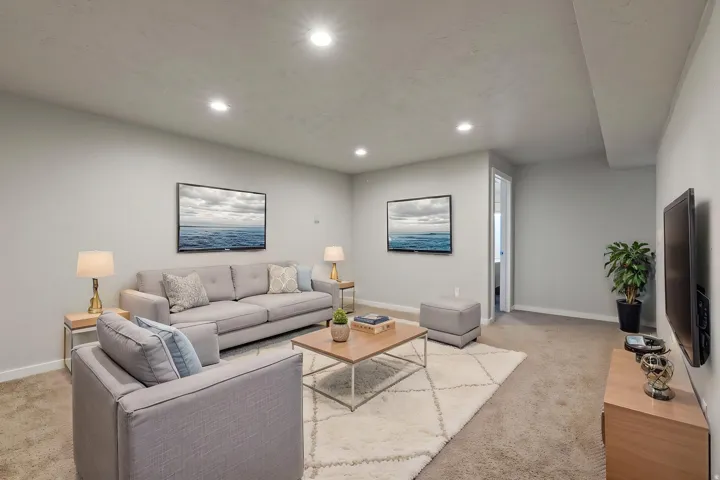 Recessed ceiling lighting, light gray walls, and carpeting throughout