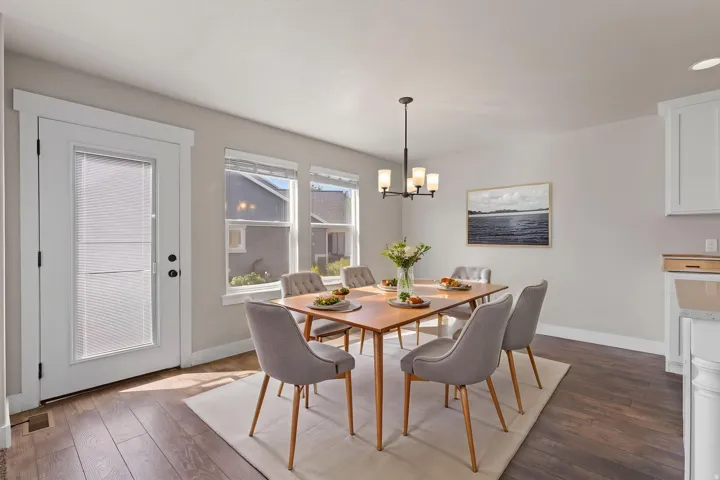 Hardwood-style flooring in a rich tone, white trim accents, and a contemporary chandelier